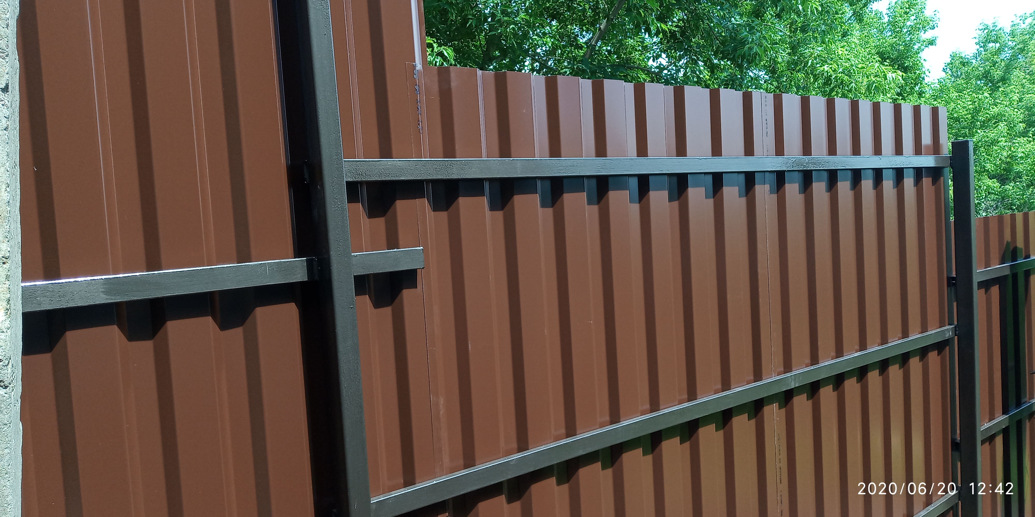 Забор из металлопрофиля (темно-коричневый) на косогоре