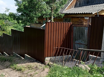 Забор из металлопрофиля (темно-коричневый) на косогоре